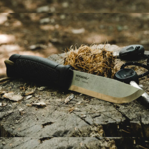 Morakniv Garberg stainless steel knife with black grip lying on a weathered tree stump