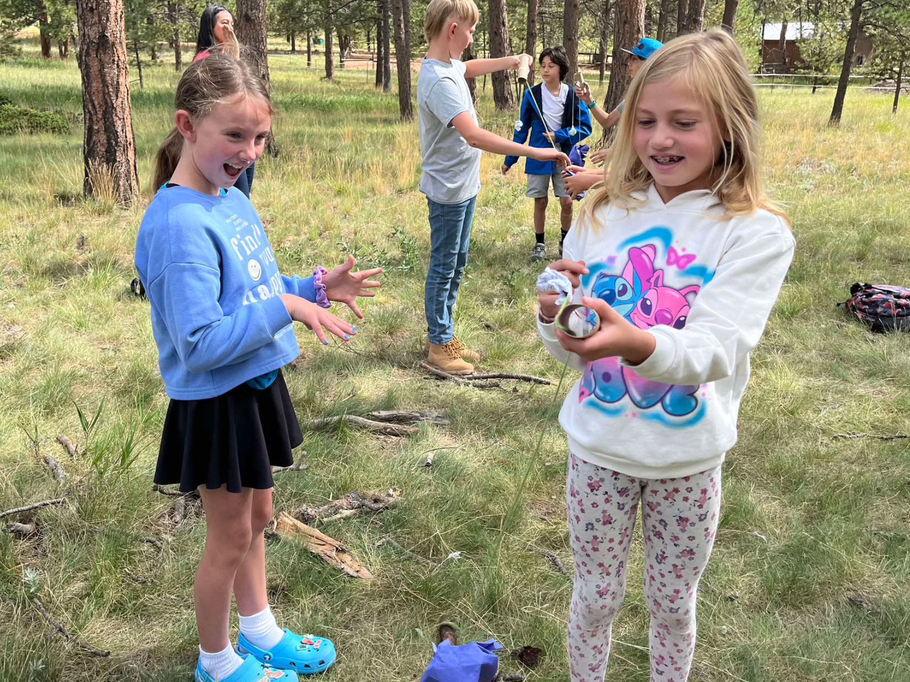 Kids smiling and learning outdoor skills during a TSU family survival class