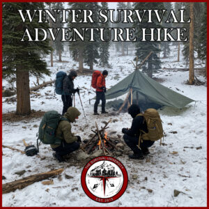 Group of hikers with large backpacks gather around a small campfire in a snowy alpine forest next to a green tarp shelter. The scene is part of a winter survival training expedition by The Survival University.